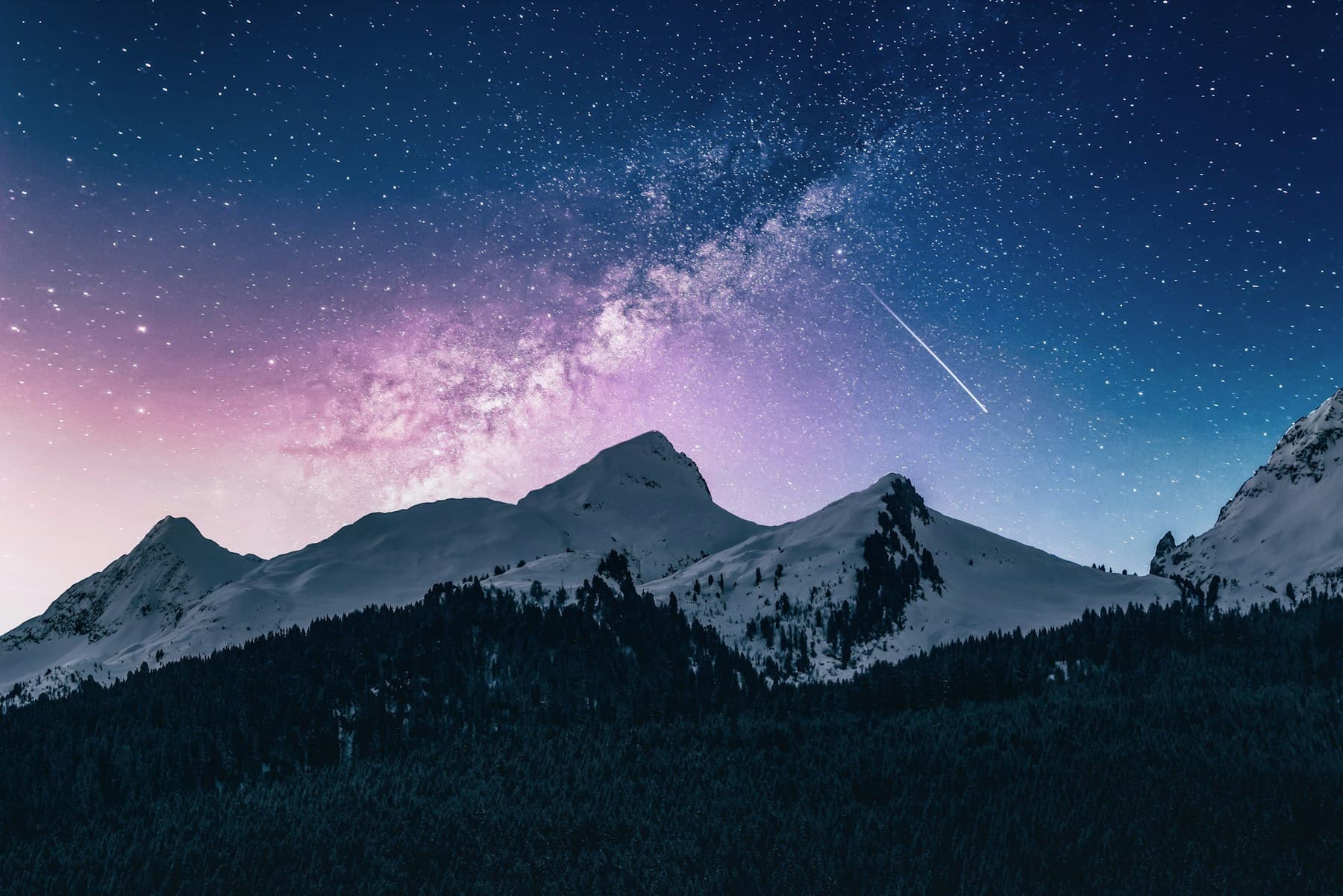 Snow-covered mountain beneath a clear star-filled night sky