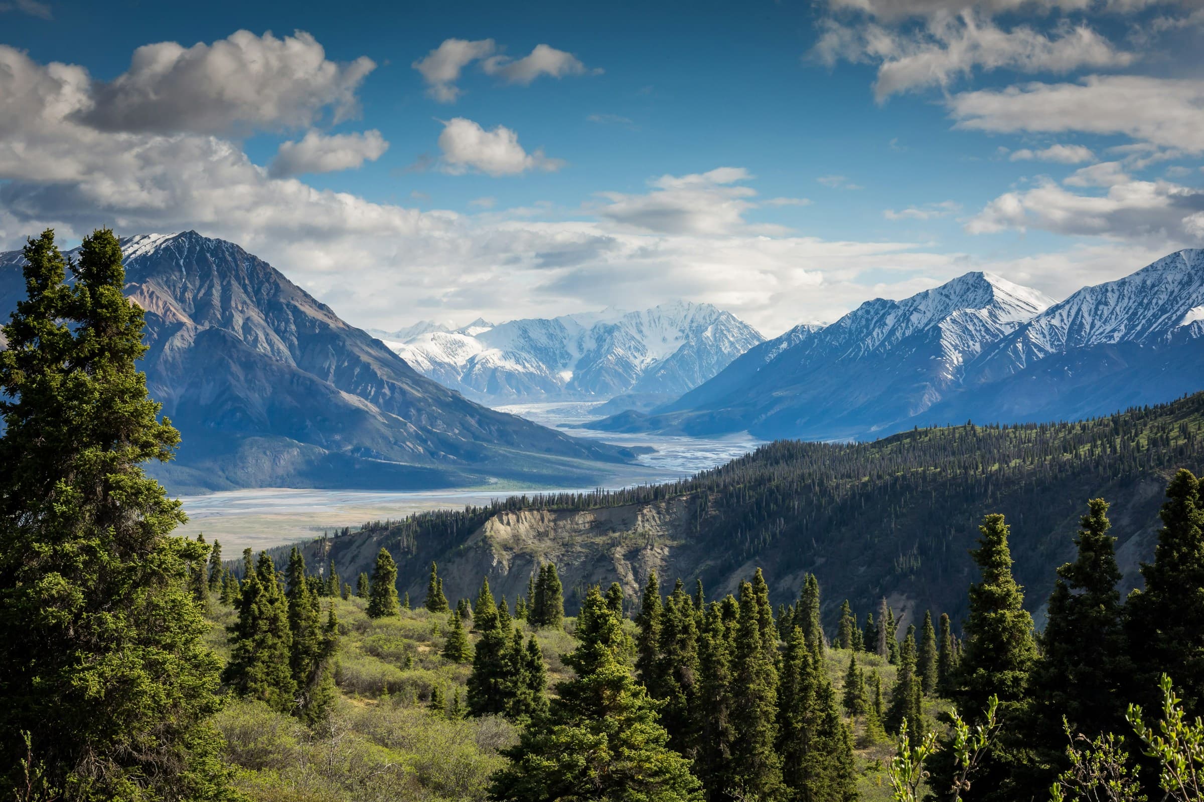 A sharp mountain ridgeline rising above an expansive alpine valley